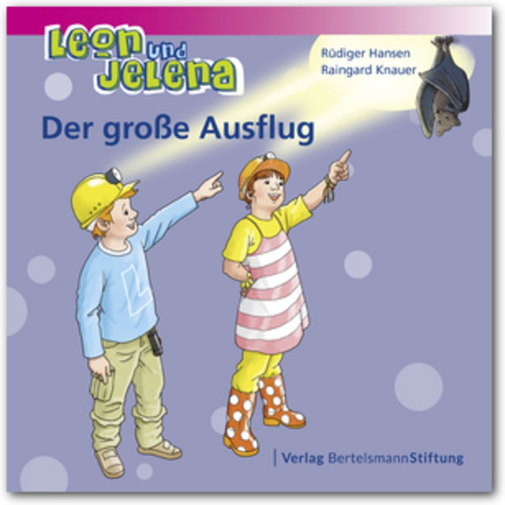 Zwei Kinder zeigen auf eine Fledermaus. Ihre Bauhelme leuchten die Fledermaus an.
